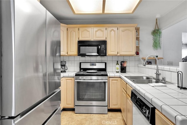 kitchen featuring light tile patterned floors, stainless steel appliances, tile counters, tasteful backsplash, and a sink