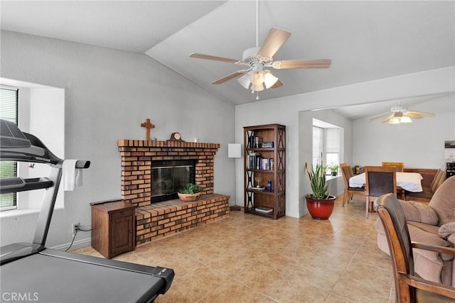 living room featuring lofted ceiling, a brick fireplace, light tile patterned floors, and a ceiling fan