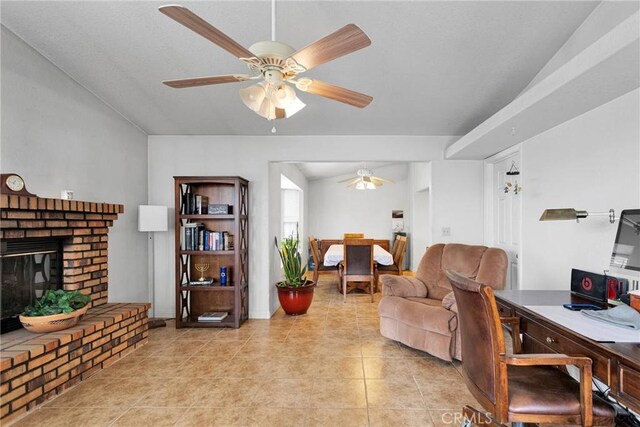 living room with light tile patterned floors, ceiling fan, a fireplace, and vaulted ceiling