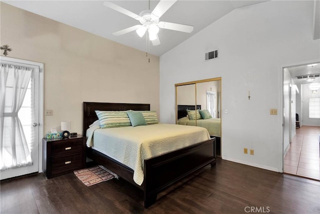 bedroom featuring high vaulted ceiling, a closet, wood finished floors, and visible vents