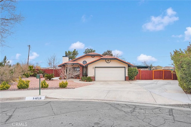 view of front facade with an attached garage, a tile roof, fence, and concrete driveway