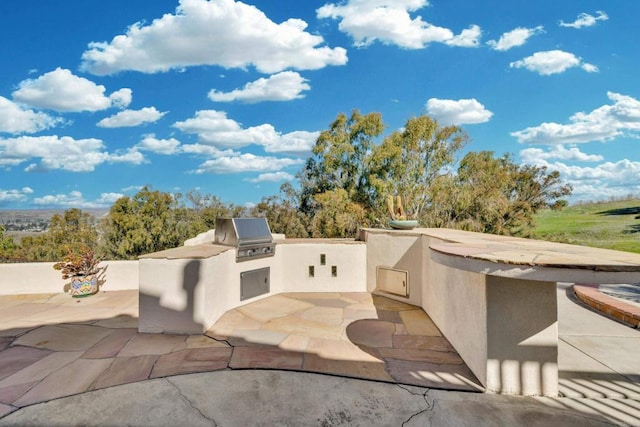 view of patio with area for grilling and an outdoor kitchen