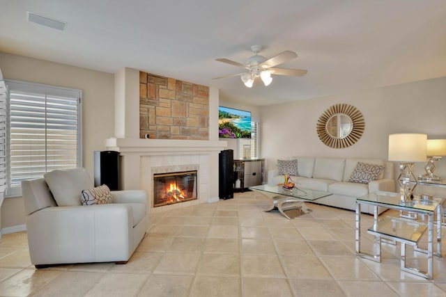 tiled living area with a ceiling fan, visible vents, and a fireplace