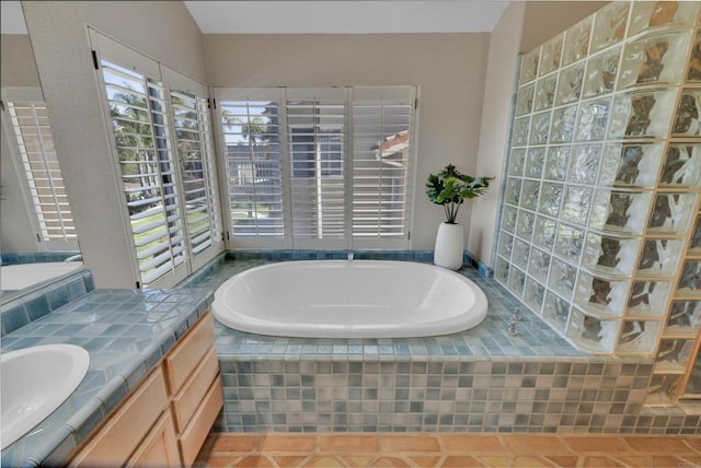 bathroom featuring tile patterned flooring, a garden tub, and vanity