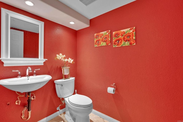 half bath with baseboards, visible vents, toilet, a sink, and recessed lighting