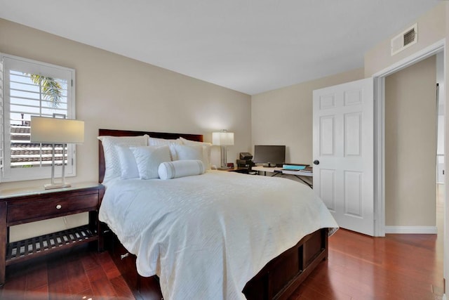 bedroom featuring dark wood-style floors, visible vents, and baseboards