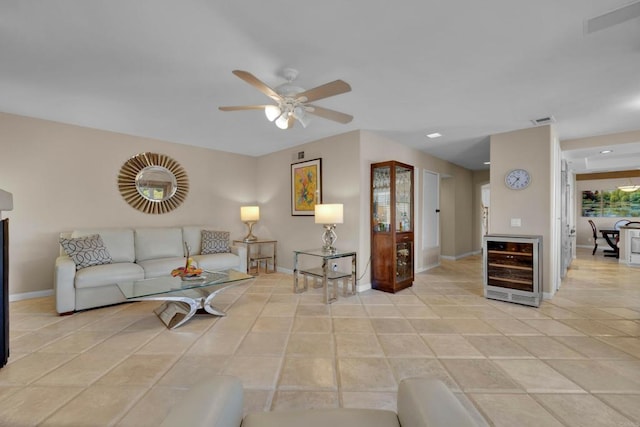 living room with light tile patterned floors, beverage cooler, a ceiling fan, visible vents, and baseboards