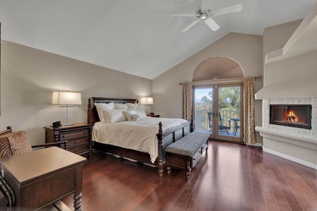 bedroom with a warm lit fireplace, ceiling fan, wood finished floors, access to outside, and high vaulted ceiling