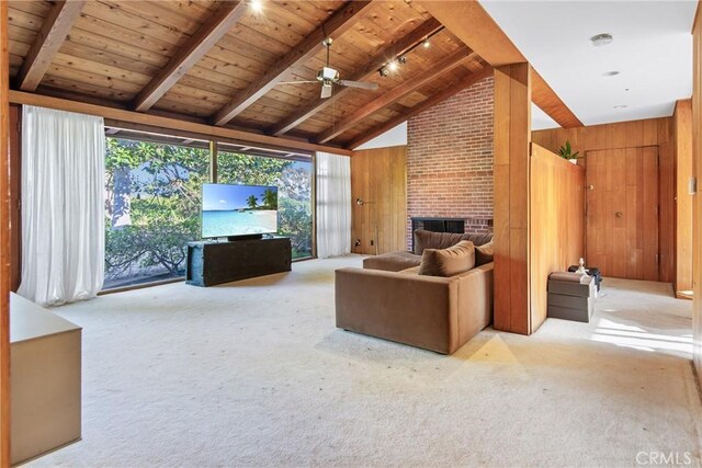 unfurnished living room with carpet, a fireplace, beam ceiling, and wooden walls