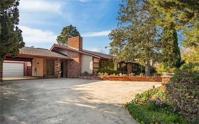 view of front of property with a garage, driveway, and a chimney