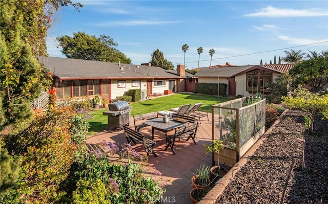 view of patio / terrace with a vegetable garden, a grill, and fence