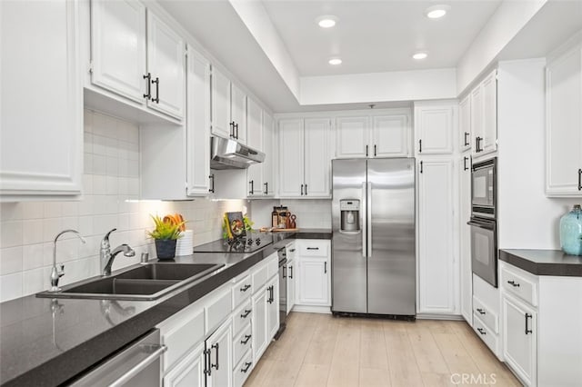 kitchen featuring black appliances, under cabinet range hood, white cabinetry, and a sink