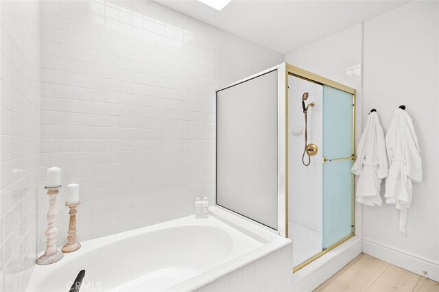 full bath with a garden tub, a shower stall, and baseboards