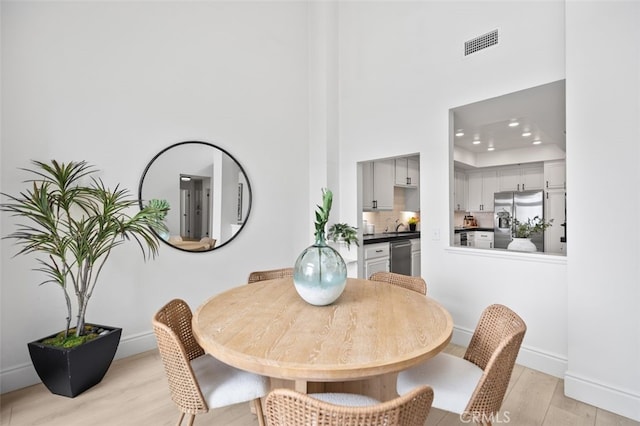 dining room with recessed lighting, visible vents, light wood-style flooring, and baseboards