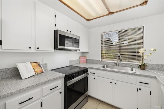 kitchen featuring a sink, white cabinetry, electric stove, light countertops, and stainless steel microwave