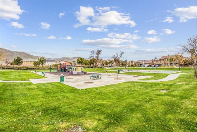 view of community featuring playground community and a lawn