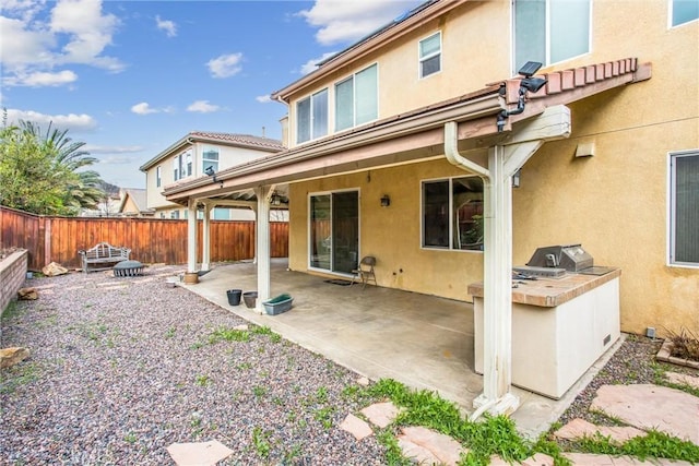 back of property featuring a patio area, fence, area for grilling, and stucco siding