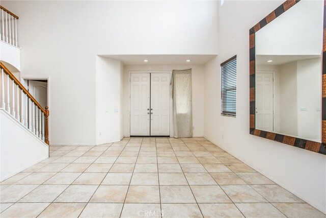 entrance foyer with light tile patterned floors, a high ceiling, stairway, and recessed lighting