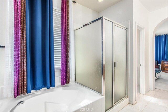 full bathroom featuring a stall shower, tile patterned flooring, and a bath