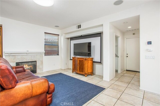 living room with light tile patterned floors, a tiled fireplace, and visible vents