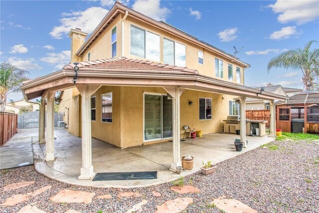 rear view of property featuring a patio, a fenced backyard, and stucco siding