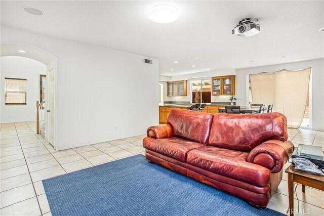 living room featuring arched walkways, visible vents, recessed lighting, and light tile patterned floors