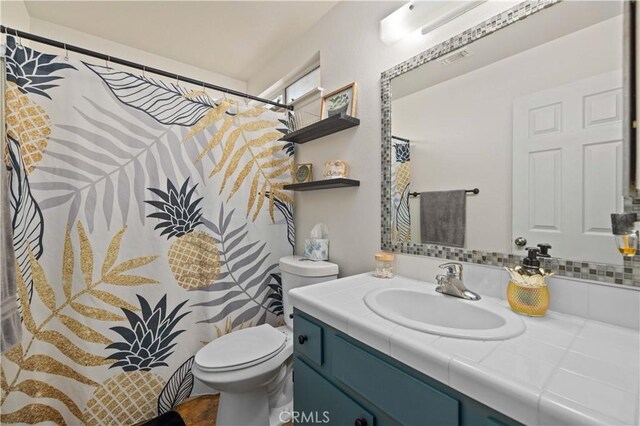 bathroom with visible vents, vanity, and toilet