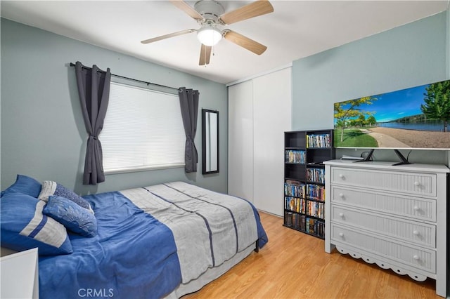 bedroom with light wood-style floors, a closet, and ceiling fan