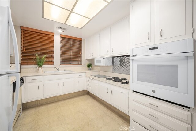 1860 Mckinney Way Unit 21L, Seal Beach, CA 90740 - kitchen with white appliances, a sink, white cabinets, light countertops, and light floors