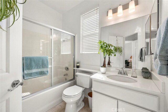 bathroom with shower / bath combination with glass door, vanity, and toilet