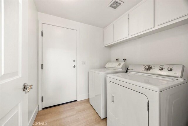 laundry area featuring independent washer and dryer, cabinet space, visible vents, and light wood-style floors