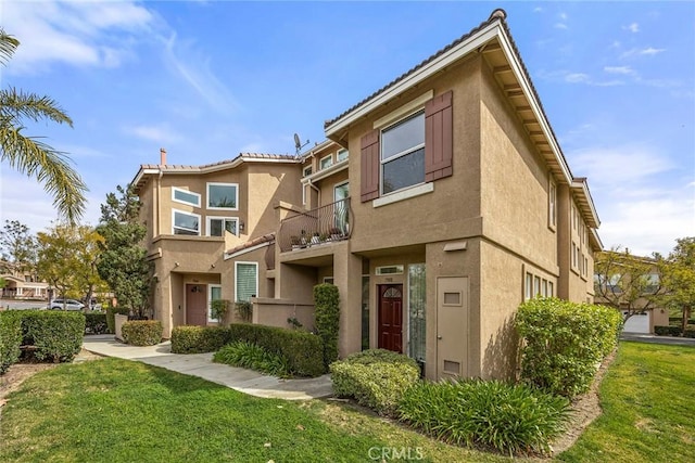 view of property with a front yard and stucco siding