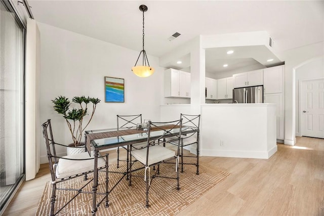 dining space with baseboards, light wood-type flooring, visible vents, and recessed lighting