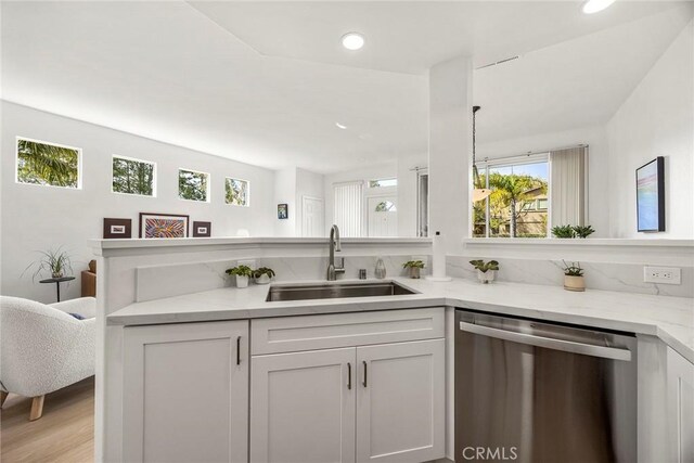 kitchen with recessed lighting, a sink, white cabinets, light stone countertops, and dishwasher