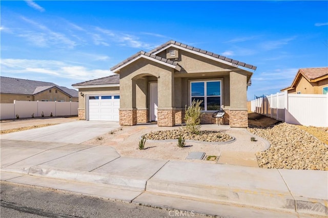 view of front of house with stucco siding, fence, a garage, stone siding, and driveway