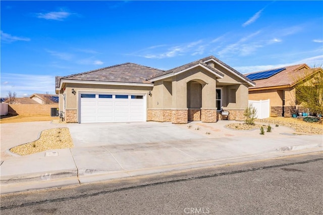 view of front of property with a garage, concrete driveway, stone siding, fence, and stucco siding