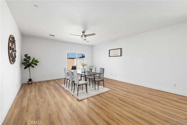 dining area featuring light wood finished floors, baseboards, visible vents, and ceiling fan