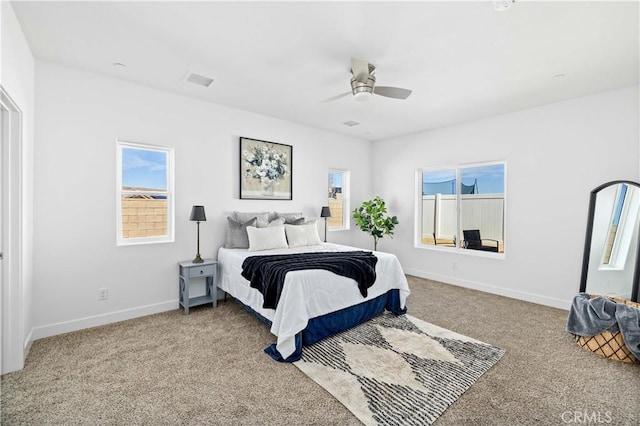 carpeted bedroom featuring a ceiling fan, visible vents, and baseboards