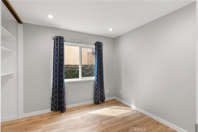 empty room featuring baseboards, wood finished floors, and recessed lighting