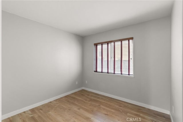 empty room with light wood-style floors and baseboards