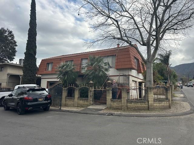 view of front of property featuring a gate, mansard roof, and a fenced front yard