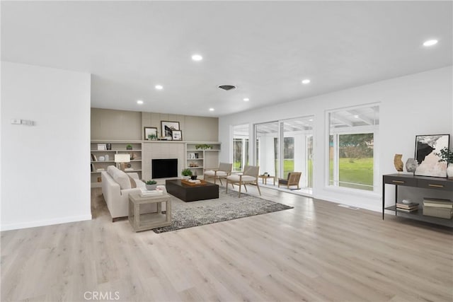 living room with a fireplace, baseboards, wood finished floors, and recessed lighting