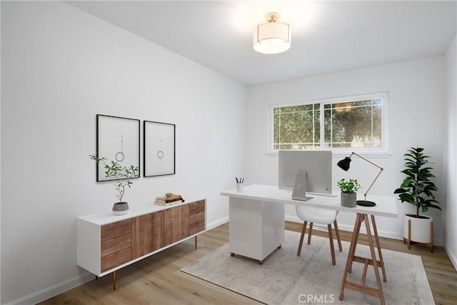 office space with light wood-style floors and baseboards