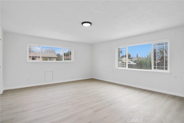 unfurnished room featuring baseboards and wood finished floors