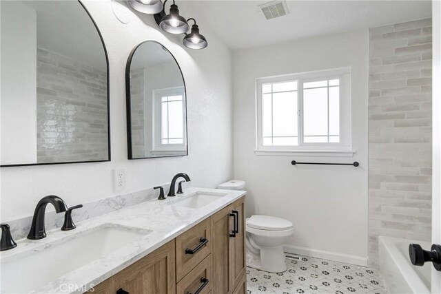 bathroom featuring toilet, baseboards, visible vents, and a sink