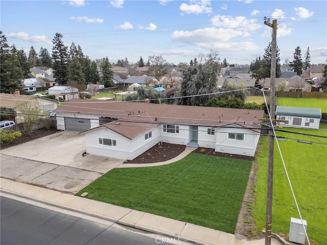 view of front of house featuring a garage, central AC unit, a residential view, fence, and a front yard