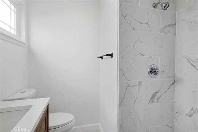 full bathroom featuring toilet, baseboards, a shower, and vanity