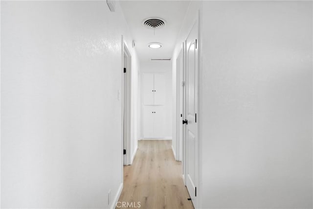 hall featuring light wood-style floors and visible vents