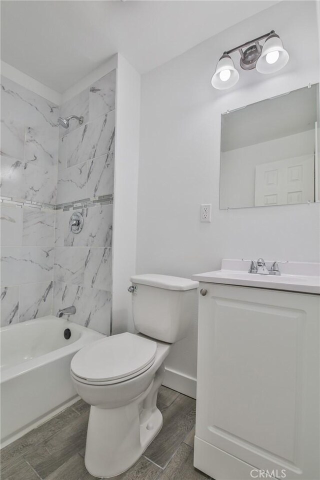 bathroom with bathing tub / shower combination, vanity, toilet, and wood finished floors