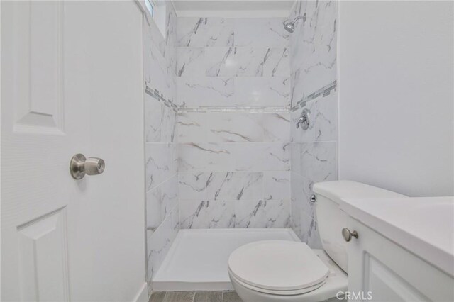 bathroom with a stall shower, vanity, and toilet